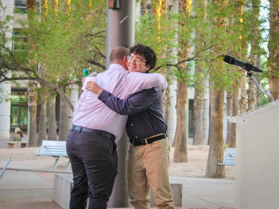 Frances McClelland Youth Vision Awardee, Daniel Trujillo, and longtime mentor and FSHD faculty, Russ Toomey, share a hug as Daniel accepts his award.