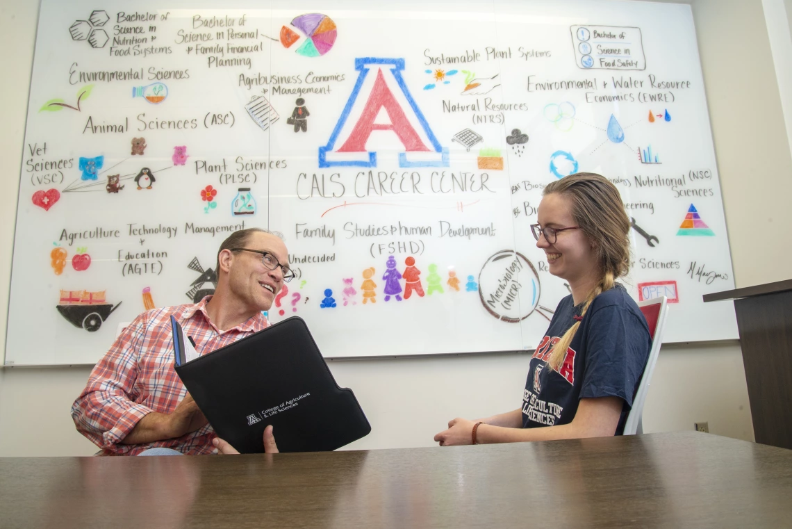 academic advisor talking with a student at the CALS career center