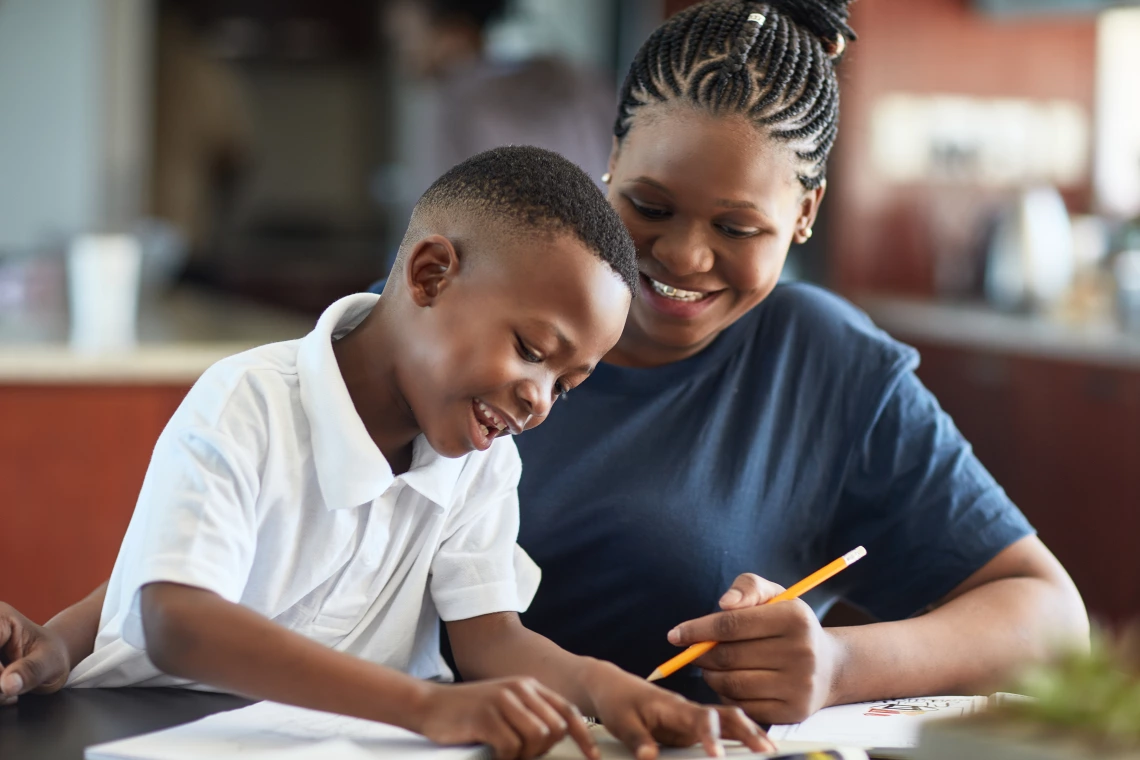 A young woman helping a child with homework.