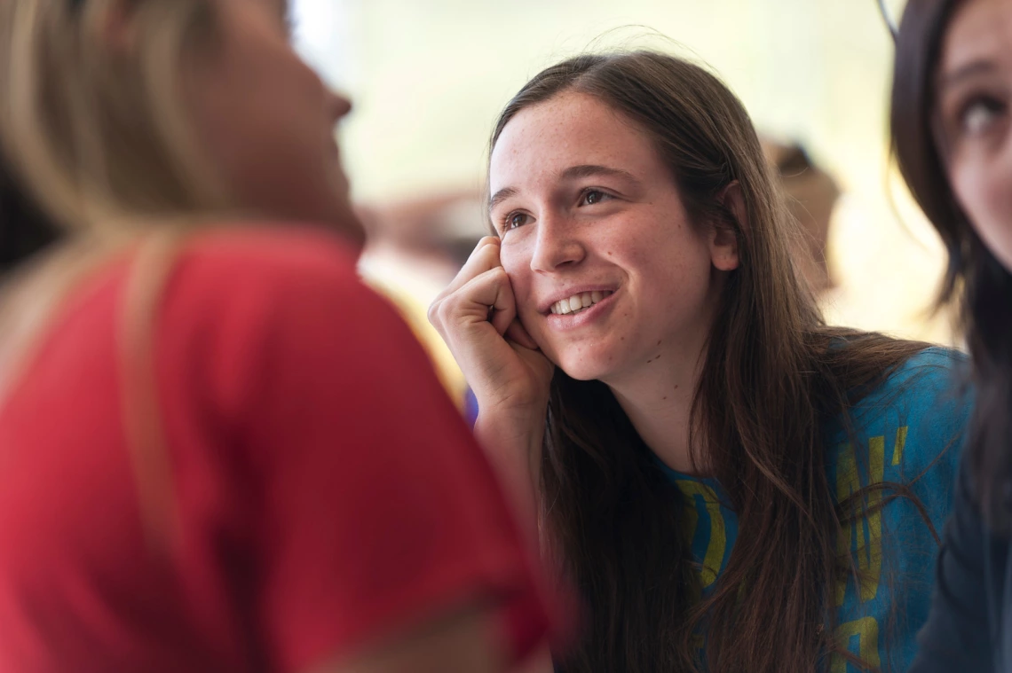 A young woman listening intently into a conversation.