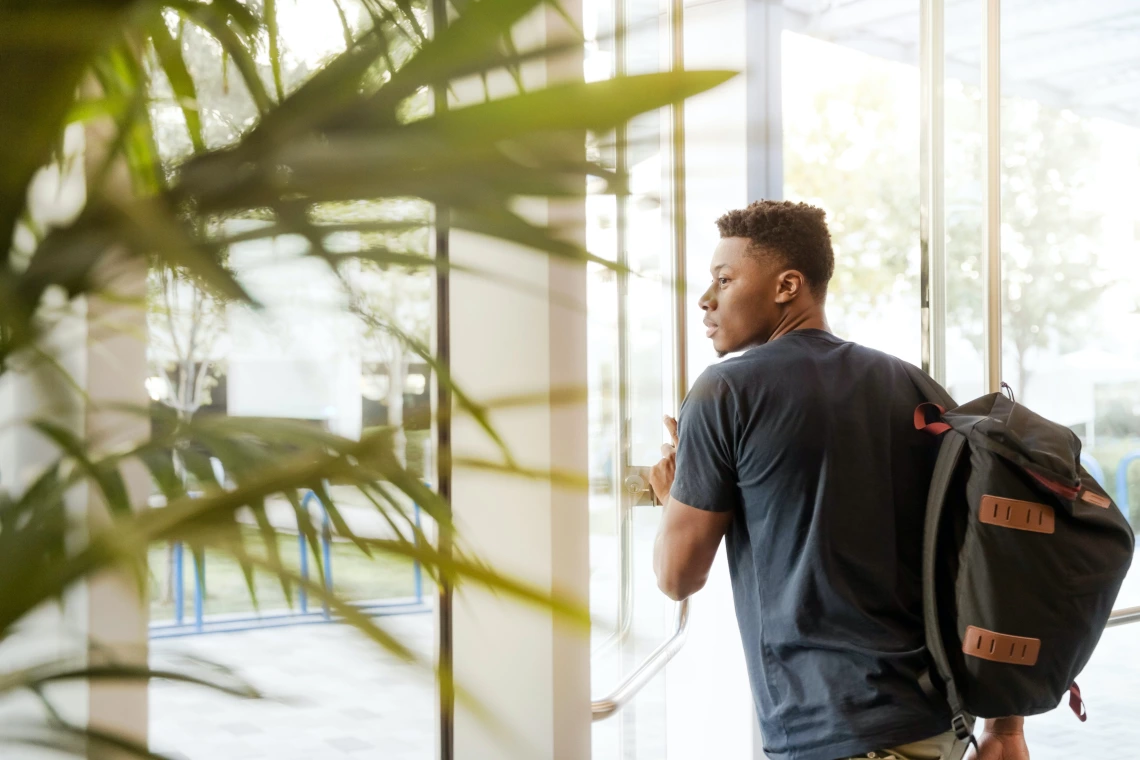 Young man walking out of a building