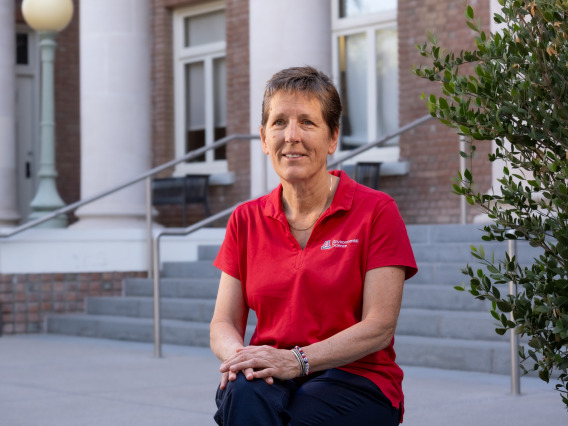 Joan Curry poses on the steps of Forbes Building on the UArizona main campus.
