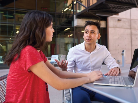 A student and advisor sitting outside.