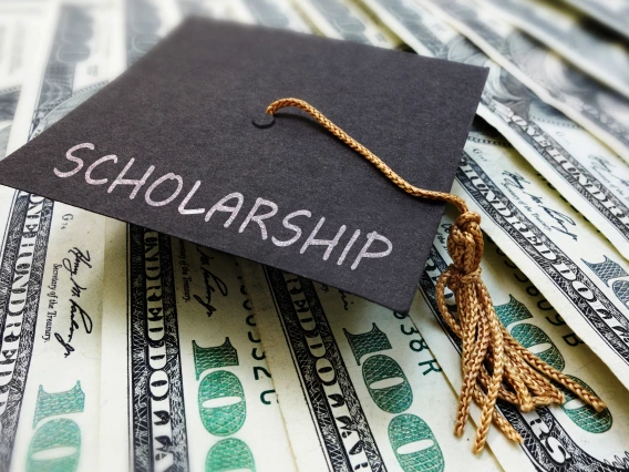 A graduation cap on top of money.