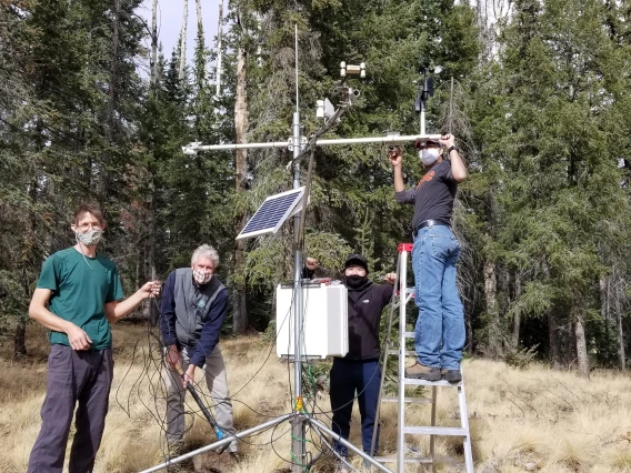 People working on geographic monitoring equipment.