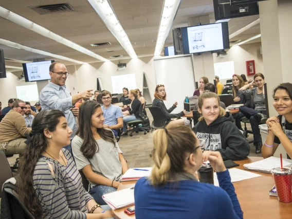 An instructor talking to a group of students in a class.