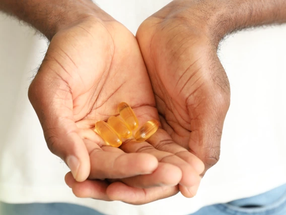 A person holds fish oil supplements in their hands