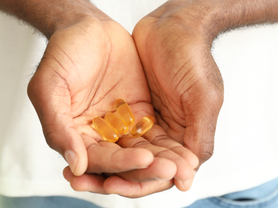 A person holds fish oil supplements in their hands