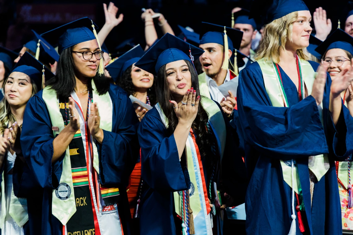 Students celebrate in graduation regalia 