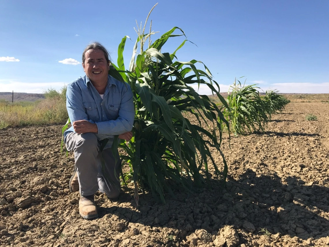 Michael Kotutwa Johnson next to corn plant