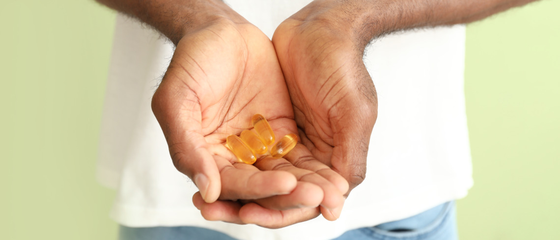 A person holds fish oil supplements in their hands