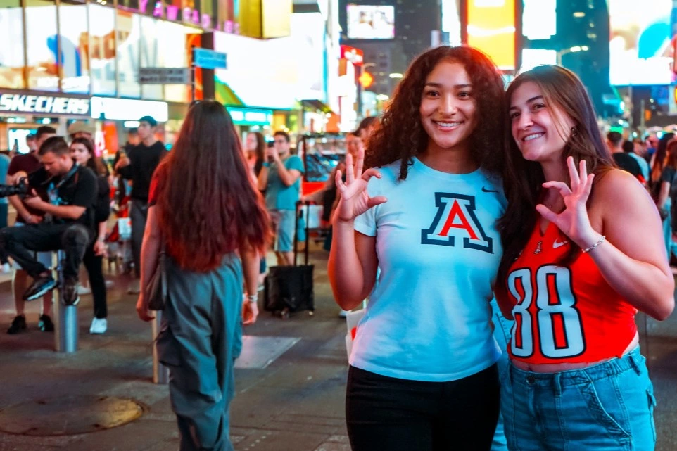 UA students making wildcat hand symbol.