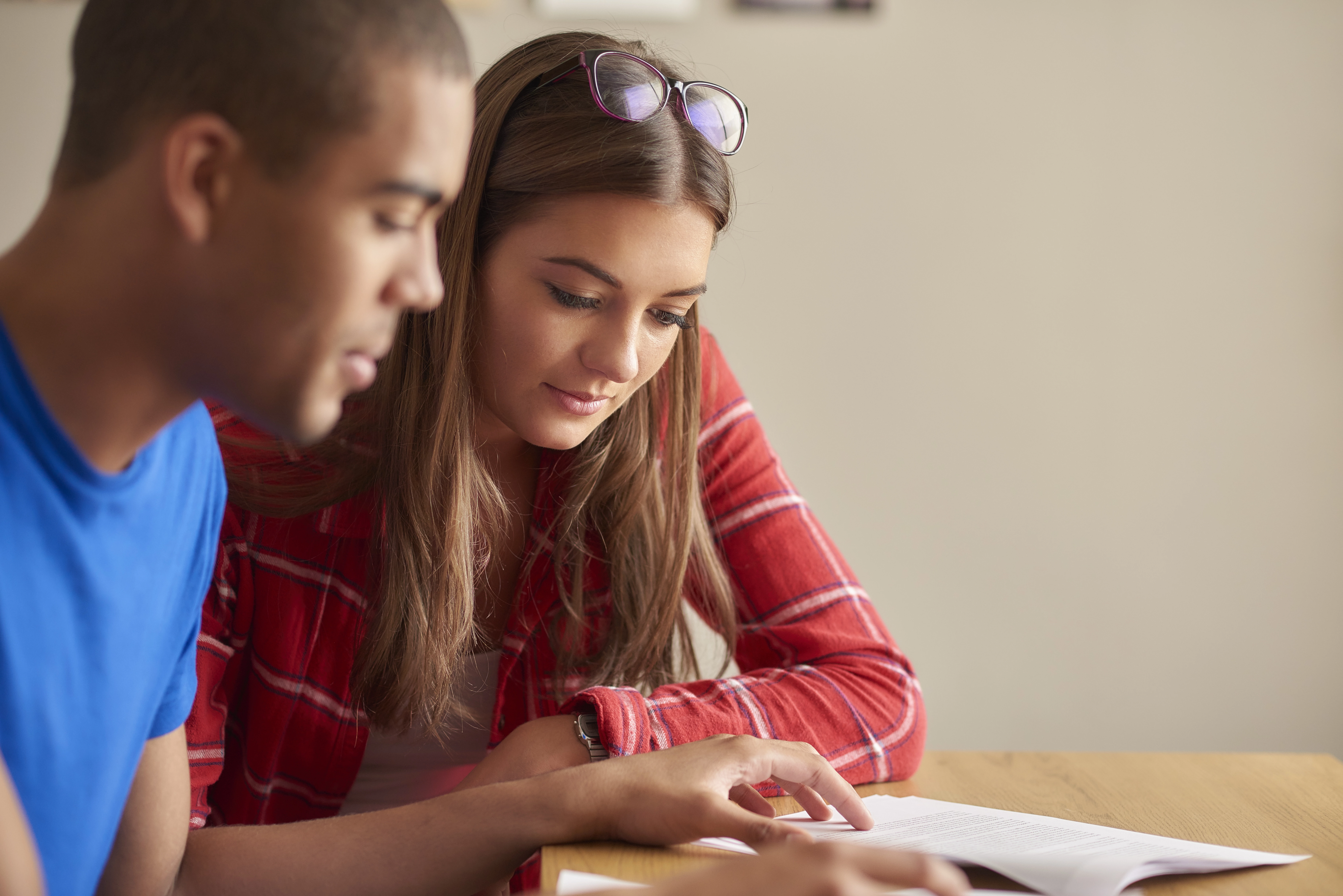 Two people sitting at a table looking over documents.