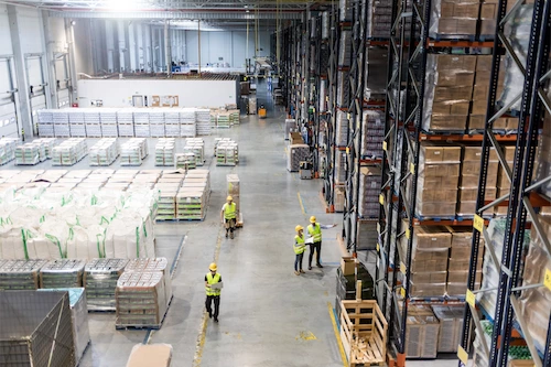 Warehouse employees working on the floor of a large, industrial