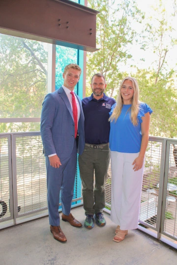 Young male and female college students posing with professor Andrew Waldum