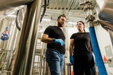 SNSW Head Brewer Patrick Heacock and fermentation science student Riley Helder work in the CALES Ales brewhouse at Cork & Craft.