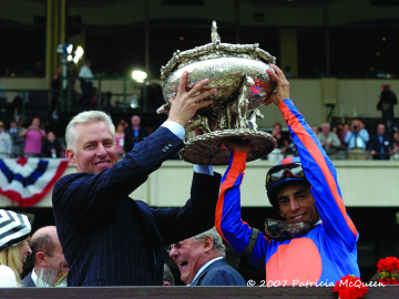 Todd Pletcher and jockey John Velazquez hold up the Belmont Stakes trophy.