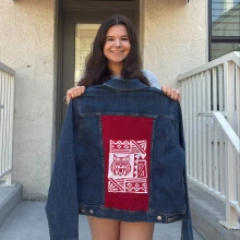 Sara Jane McKeighan holds one of her custom denim jackets