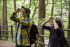 Picture of two people looking through binoculars in a forest.