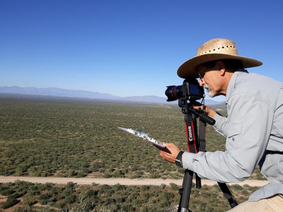Mitch McClaran taking a Repeat Photos from the top of the Huerfano Butte.jpg