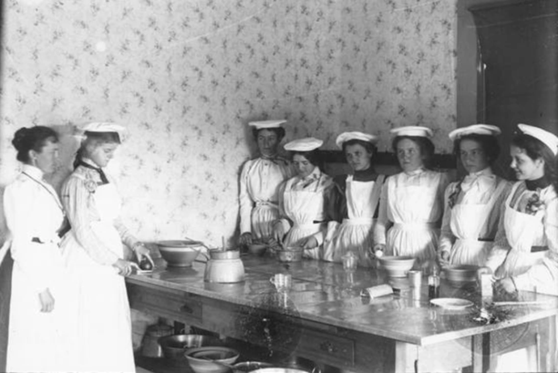 black and white image of students in the early 20th century in domestic science lab